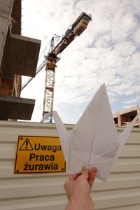 At a construction site (the plaque says “Uwaga. Praca żurawia” which means “Warning. Crane at work” in Polish)